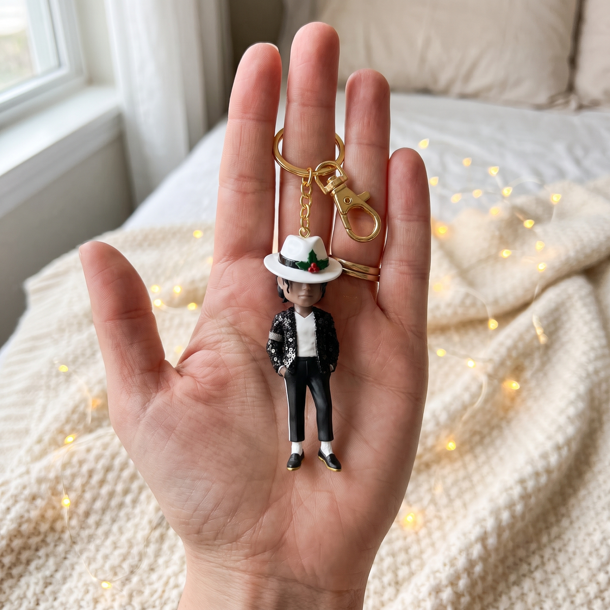 The tiny Toe Stand keychain lying in an open palm